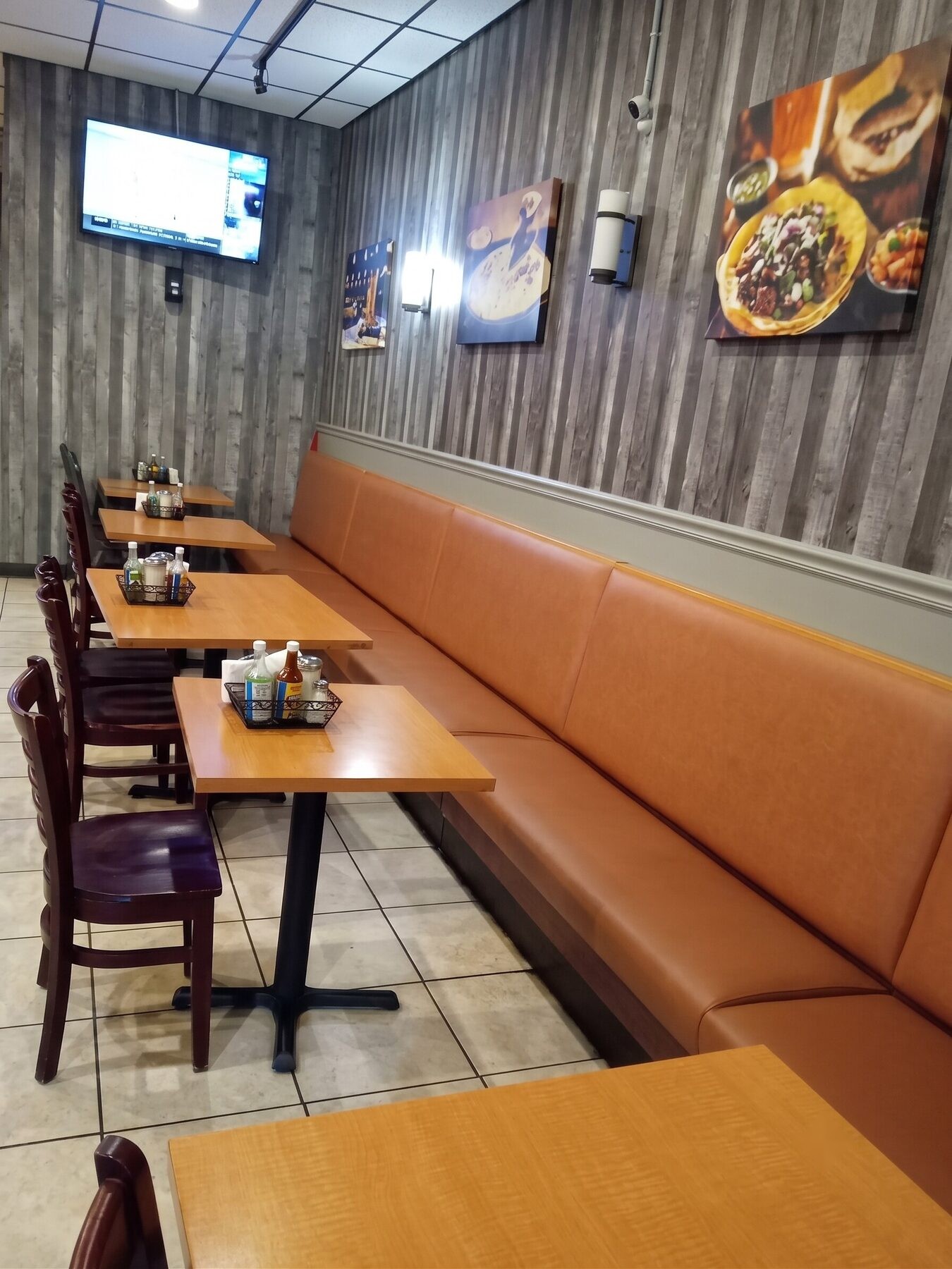 Full-length banquette in camel vinyl running the length of a taqueria dining room