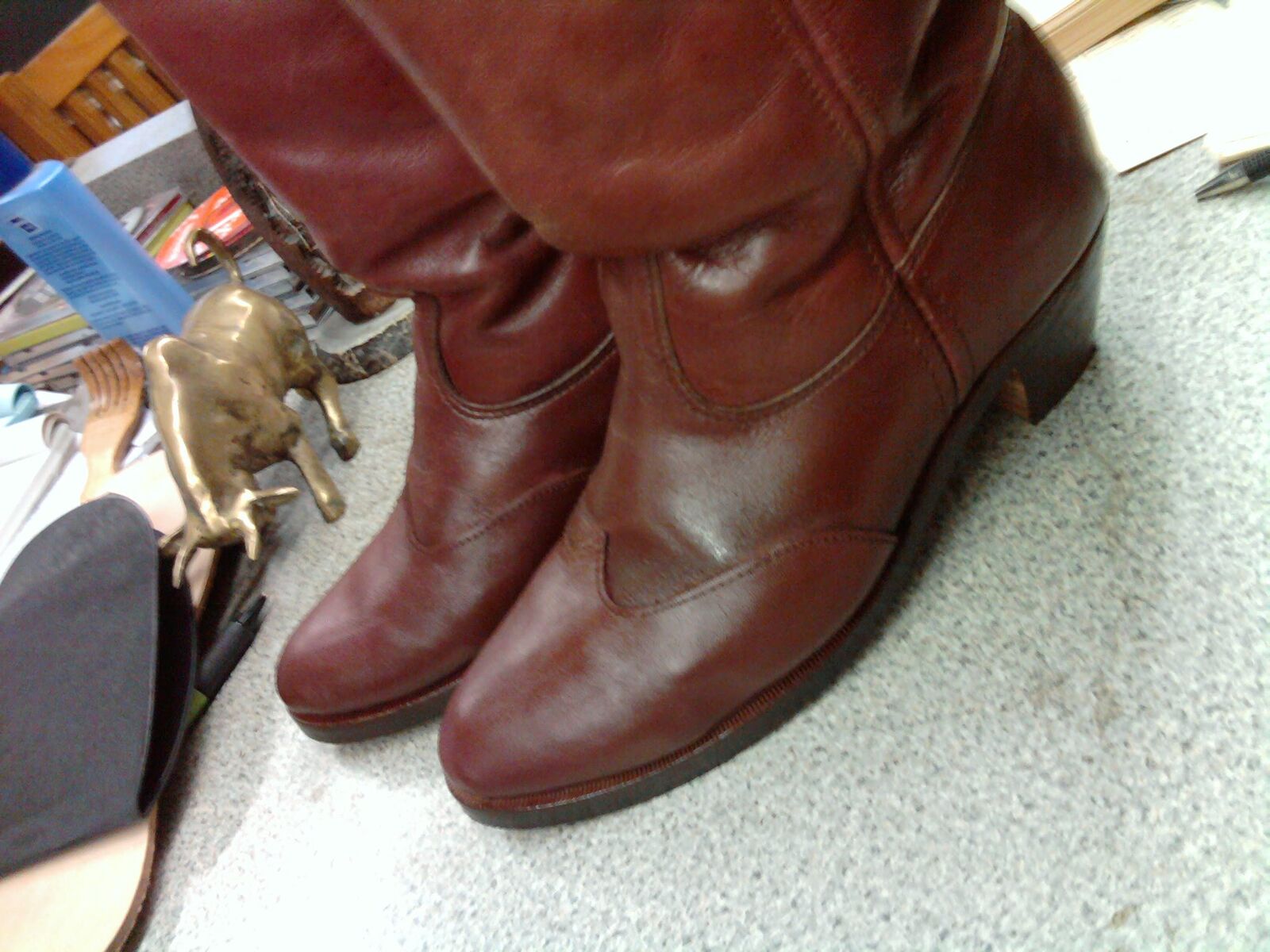 Pair of brown leather pull-on boots with stacked heels on the shop counter