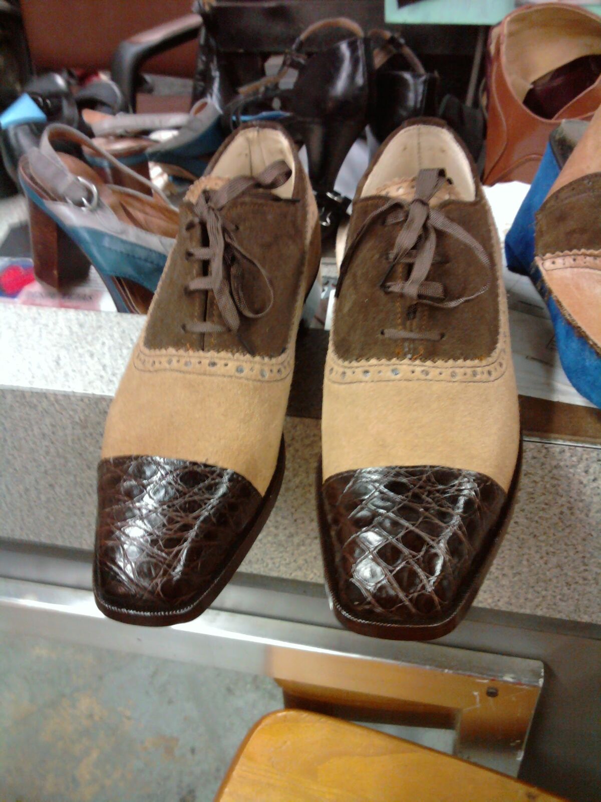 Pair of two-tone suede saddle oxfords with dark crocodile cap toes and brogue detailing